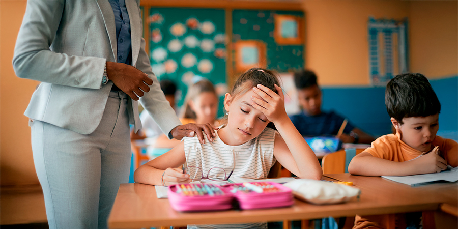 menina com a mão na testa com dor de cabeça 
