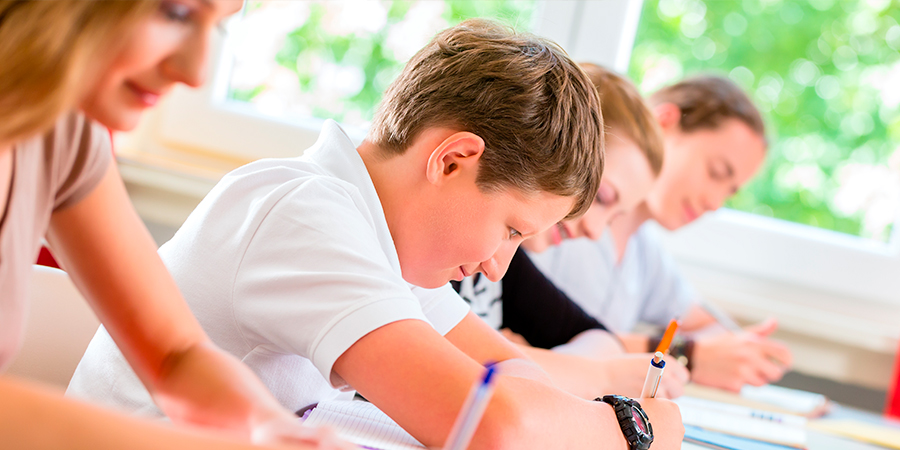 menino fazendo teste escrito 