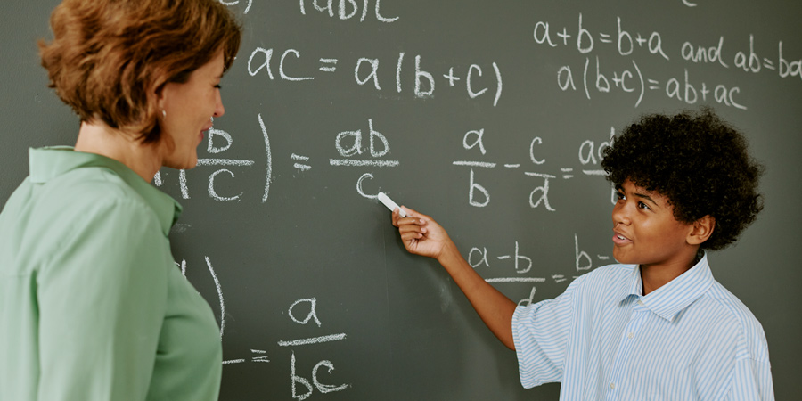 Aluno resolvendo equações matemáticas na lousa