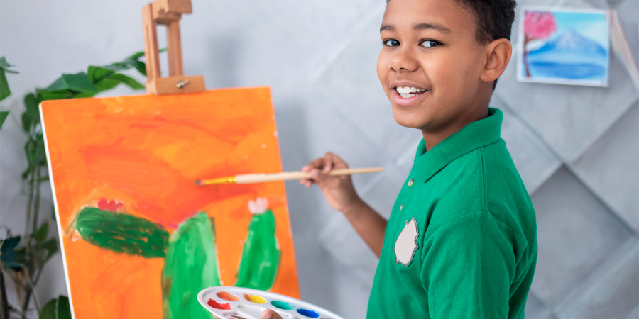 Menino pintando uma tela 